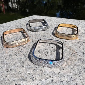 Könnte beinhalten: Vier verschiedene quadratische Uhrengehäuse mit einem diamantartigen Design. Die Gehäuse sind in Silber, Gold und zwei Roségoldtönen.