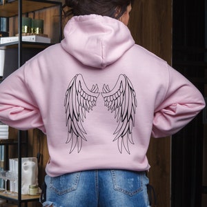 May include: A pink hoodie with a black outline of angel wings on the back.