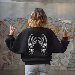 May include: Black sweatshirt with white angel wings printed on the back.