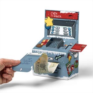 Könnte beinhalten: Eine blaue und weiße Papp-Kasse mit einem roten Dach und einem Stern oben drauf. Die Kasse hat einen Schlitz für eine Kreditkarte und einen Schlitz für Bargeld. Die Kasse ist mit "Cash from Santa" beschriftet.