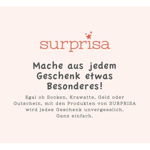 May include: A pink and white graphic with the text "surprisa" in red. The text below reads "Mache aus jedem Geschenk etwas Besonderes!" and "Egal ob Socken, Krawatte, Geld oder Gutschein, mit den Produkten von SURPRISA wird jedes Geschenk unvergesslich. Ganz einfach."