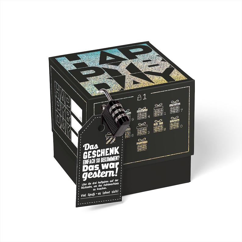 May include: A black gift box with a glittery holographic design that says "Happy Birthday". The box has a combination lock on it and a tag that says "Das Geschenk einfach so bekommen? Das war gestern!"  L&ouml;se die drei Aufgaben auf der R&uuml;ckseite, um das Zahlenschloss zu knacken. Viel Spa&szlig; - es lohnt sich!
