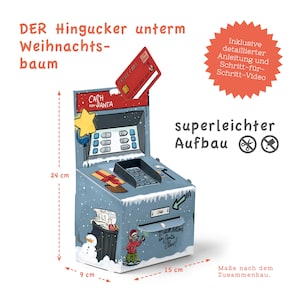 May include: A cardboard model of a Christmas ATM with a red credit card sticking out of the slot. The ATM is decorated with a snowman, a trash can, and a small elf. The ATM is 9 cm wide, 15 cm long, and 24 cm tall. The text on the ATM reads "Cash from Santa".