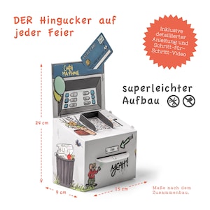 May include: A cardboard model of a cash machine with a cartoon design. The model is 9 cm wide, 15 cm long, and 24 cm tall. The model includes a credit card, a balloon, and the text "Cash Machine" and "Yeah!"