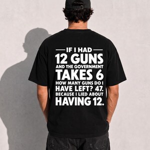 Puede incluir: Una camiseta negra con texto blanco en la parte posterior que dice: IF I HAD 12 GUNS AND THE GOVERNMENT TAKES 6 HOW MANY GUNS DO I HAVE LEFT? 47. BECAUSE I LIED ABOUT HAVING 12. La camiseta tiene mangas cortas y cuello redondo.