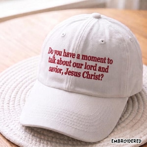 Könnte beinhalten: Eine weiße Baseballkappe mit rotem gesticktem Text auf der Vorderseite, der lautet: "Do you have a moment to talk about our lord and savior, Jesus Christ?" Die Kappe hat eine strukturierte Krone, einen gebogenen Schirm und Belüftungsösen.