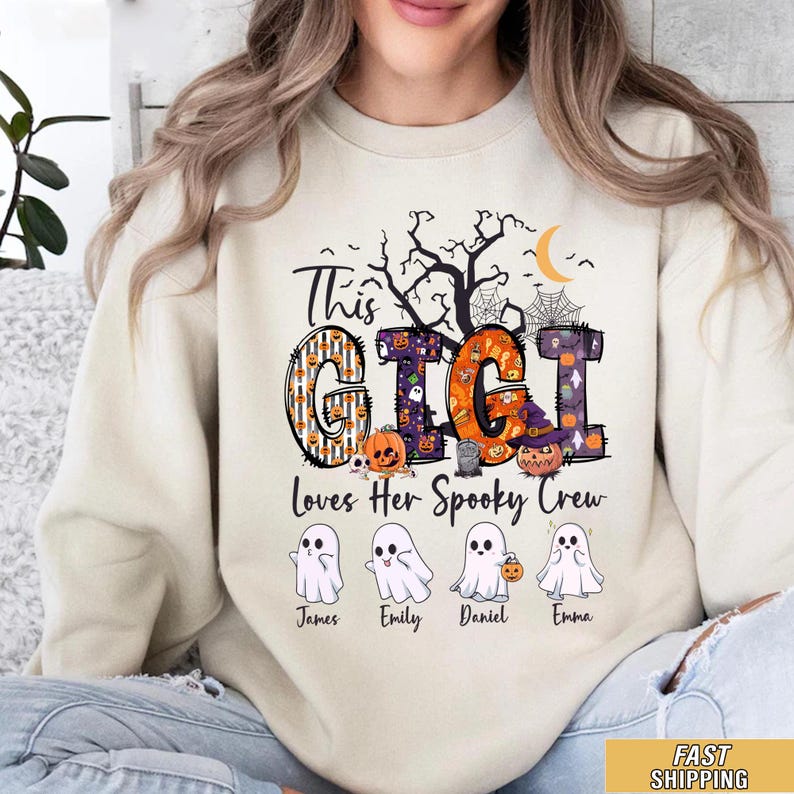 May include: A cream-colored crewneck sweatshirt featuring a graphic with the text This GIGI Loves Her Spooky Crew. The design includes a black tree, spiderwebs, a crescent moon, and four white ghost illustrations labeled James, Emily, Daniel, and Emma.