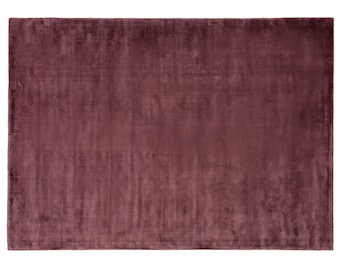 May include: A solid, deep burgundy-colored rug with a subtle, textured surface. The rug is rectangular and has a smooth, even texture.