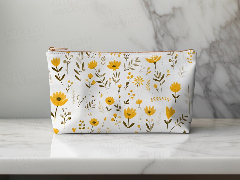 May include: A white zippered pouch with a repeating pattern of yellow flowers and brown stems on a white background.