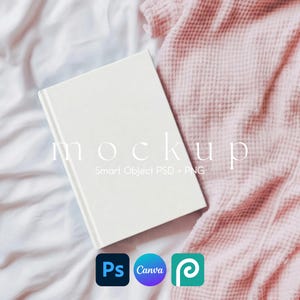 May include: A white book mockup with the word "mockup" printed on the cover. The book is on a white surface with a pink waffle-textured fabric. The image also includes the logos for Photoshop, Canva, and Placeit.