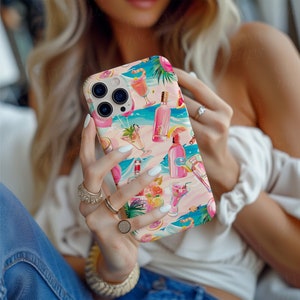 Op de afbeelding: Een telefoonhoesje met een kleurrijk strandthema, met cocktails, flessen en tropische elementen in roze, blauw en oranje. De hoes heeft een glanzende afwerking en wordt door een persoon vastgehouden.