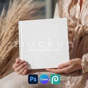 May include: A white square book mockup held by a person. The word "mockup" is printed on the cover. Below the word are the words "Smart Object PSD + PNG". The image also includes the logos for Photoshop, Canva, and Placeit.