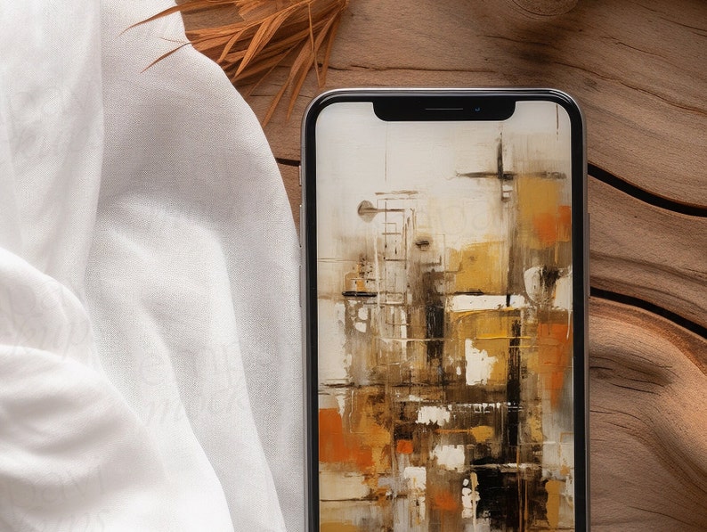 Blank black smartphone on natural wood with soft white fabric and dried leaves, creating a warm, organic setting for mobile design presentations