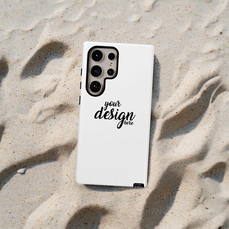 May include: White phone case with a black outline and a camera lens cutout. The case has the text "your design here" printed on it.