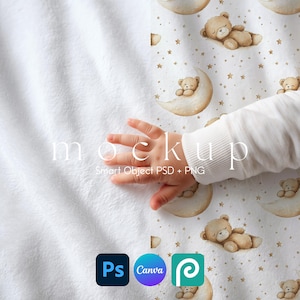 May include: A white baby blanket featuring a pattern of teddy bears, crescent moons, and stars. The blanket has a soft, fluffy texture. The image also shows a baby's hand and the word "mockup".
