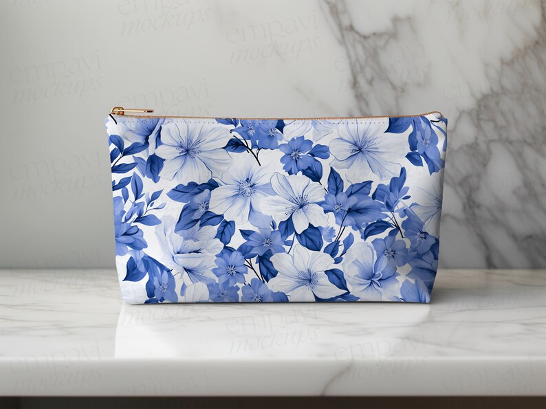 May include: A white zippered pouch with a blue floral pattern. The pouch is made of fabric and has a zipper closure.