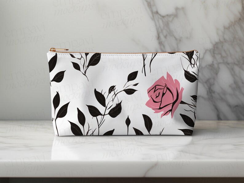 May include: A white zippered pouch with a black and pink floral pattern. The pattern features black leaves and stems with pink roses.