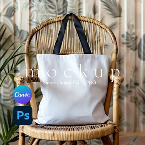 May include: White tote bag with black handles sitting on a wicker chair. The bag is blank and ready for customization.  The text "mockup Smart Object PSD + PNG" is printed on the bag.