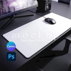 May include: A white mousepad with a black border and a black computer mouse on top. The mousepad has the text "mockup" and "Smart Object PSD + PNG" printed on it. The mousepad is on a black surface.