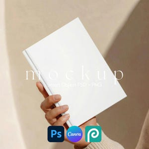 May include: A white book mockup held in a person's hand, with the word "mockup" and the text "Smart Object PSD + PNG" printed on the cover. The image also includes the logos for Adobe Photoshop, Canva, and Pinterest.