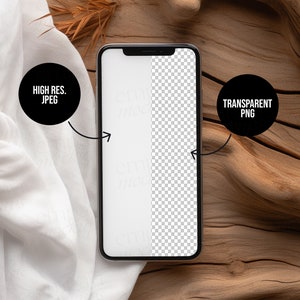 Blank black smartphone on natural wood with soft white fabric and dried leaves, creating a warm, organic setting for mobile design presentations