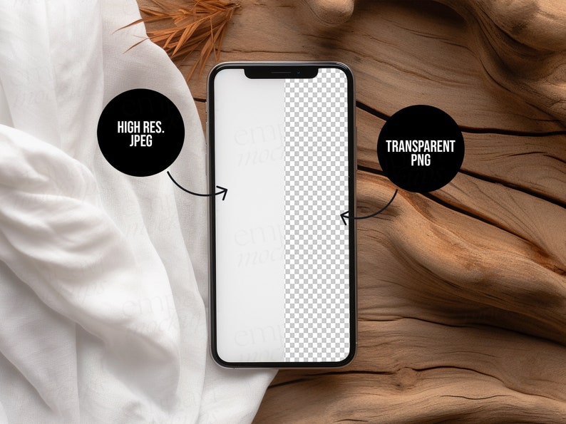 Blank black smartphone on natural wood with soft white fabric and dried leaves, creating a warm, organic setting for mobile design presentations