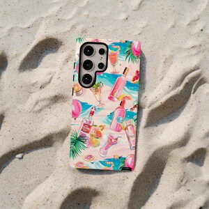 May include: A white phone case with a colorful pattern of cocktails, fruit, and palm leaves. The case has a camera cutout with a black ring around it.