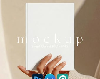 May include: A blank white hardcover book mockup held in a hand, featuring the text mockup Smart Object PSD + PNG. The book has a clean, solid white cover and is presented with Photoshop, Canva, and generic software icons at the bottom.