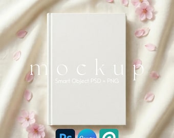 May include: A white book mockup with the word "mockup" in a delicate font. The book is surrounded by pink cherry blossoms and petals on a cream-colored fabric. Includes the logos for Photoshop, Canva, and Placeit.