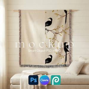 May include: A woven throw blanket featuring a beige background with a repeating pattern of black birds perched on thin brown branches with small yellow leaves. The blanket has fringed edges and is displayed hanging on a wooden rod.