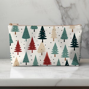 May include: A white zippered pouch with a repeating pattern of stylized Christmas trees in red, green, and cream. The trees have small black dots scattered around them.
