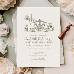 以下が含まれることがあります： 教会が描かれた、エレガントな結婚式の招待状。「Elizabeth & Andrew が結婚式にご招待」と日付と時間が記載されています。ワックスシールと指輪の入ったリングボックスも写っています。