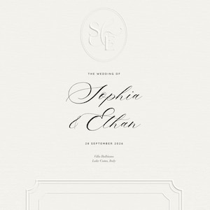 May include: Cream-colored wedding invitation with embossed initials in a circle at the top. The names "Sophia & Ethan" are written in elegant script, along with the wedding date and location: Villa Balbiano, Lake Como, Italy.