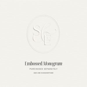 May include: A white embossed monogram design featuring the letters "S" and "E" within a circular border. The text "Embossed Monogram" is below the design, with additional text indicating the item is purchased separately.