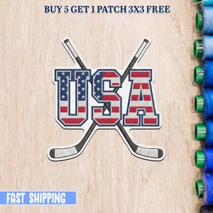 Może przedstawiać: Haftowana naszywka z napisem "USA" w kolorze czerwonym, białym i niebieskim, z motywem kija hokejowego. Naszywka zawiera tekst "BUY 5 GET 1 PATCH 3X3 FREE" i "FAST SHIPPING".