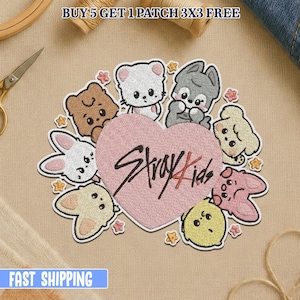 Könnte beinhalten: Gestickter Aufnäher mit einem rosa Herz, dem Text "Stray Kids" und Cartoon-Tierfiguren. Der Aufnäher hat einen cremefarbenen Rand und befindet sich auf einem beigefarbenen Stoff. Der Text "BUY 5 GET 1 PATCH 3X3 FREE" steht oben.
