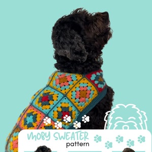 Pu&ograve; includere: Un cane nero che indossa un maglione all'uncinetto colorato con un motivo a quadrati della nonna. Il maglione &egrave; etichettato "Moby Sweater pattern" e "Yarn Heads Mad Paws".