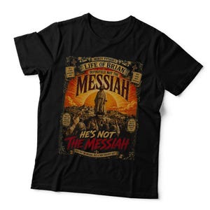 May include: A black short-sleeved t-shirt featuring a graphic print from Monty Python's Life of Brian. The design includes the text "Life of Brian," "Messiah," and "He's Not The Messiah" with an illustration of a figure standing before a sun.