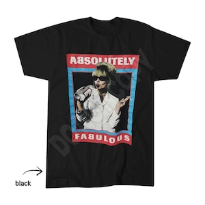 May include: A black short-sleeved t-shirt featuring a central graphic print of a person with a tall hairstyle wearing sunglasses, holding a bottle and a cigarette. The text "ABSOLUTELY" and "FABULOUS" appears in white within a red and blue border.