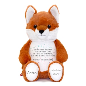 Könnte beinhalten: Ein Plüsch-Fuchs-Spielzeug mit weißem Bauch und braunem Fell. Das Spielzeug hat eine Botschaft auf seinem Bauch, die lautet: "Sei still wie ein Mäuschen, pass auf wie ein Luchs, sei fleißig wie ein Bienchen, dann wirst du schlau wie ein Fuchs. Alles Gute zum Schulanfang!" Das Spielzeug trägt auch den Namen "Anton" und "Schulkind 2024" auf seinen Pfoten.