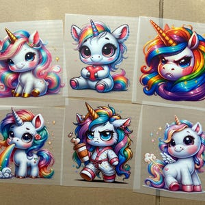 Könnte beinhalten: Sechs bunte Bügelbilder mit niedlichen Comic-Einhörnern mit Regenbogenmähne und -schwanz. Die Einhörner sind in verschiedenen Posen, darunter mit einem Herzen, beim Kaffeetrinken und beim Erbrechen eines Regenbogens.