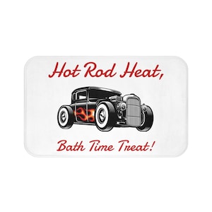 May include: A white bath mat with a black and white illustration of a hot rod car with flames coming from the side. The text "Hot Rod Heat, Bath Time Treat!" is written in red.