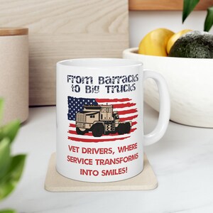 May include: White ceramic mug with a graphic of a military truck in front of an American flag. The text reads "From Barracks to Big Trucks Vet Drivers, Where Service Transforms Into Smiles!"