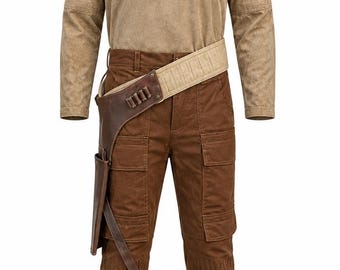 May include: A tan long-sleeved shirt with a high collar paired with brown cargo pants. A wide, light-colored utility belt with a dark brown leather holster attachment featuring four small metallic cylinders is worn over the pants at the waist.