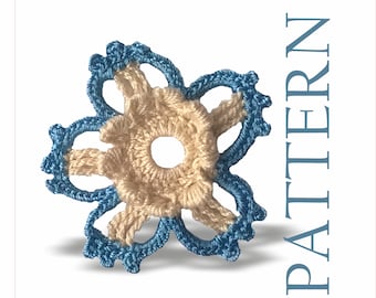 May include: A crocheted flower with a light blue outer edge and a beige center. The flower has five petals and a hole in the center.