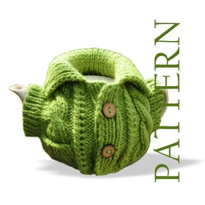 May include: Green knitted teapot cozy with button closures. The cozy is shaped like a cardigan with a collar.