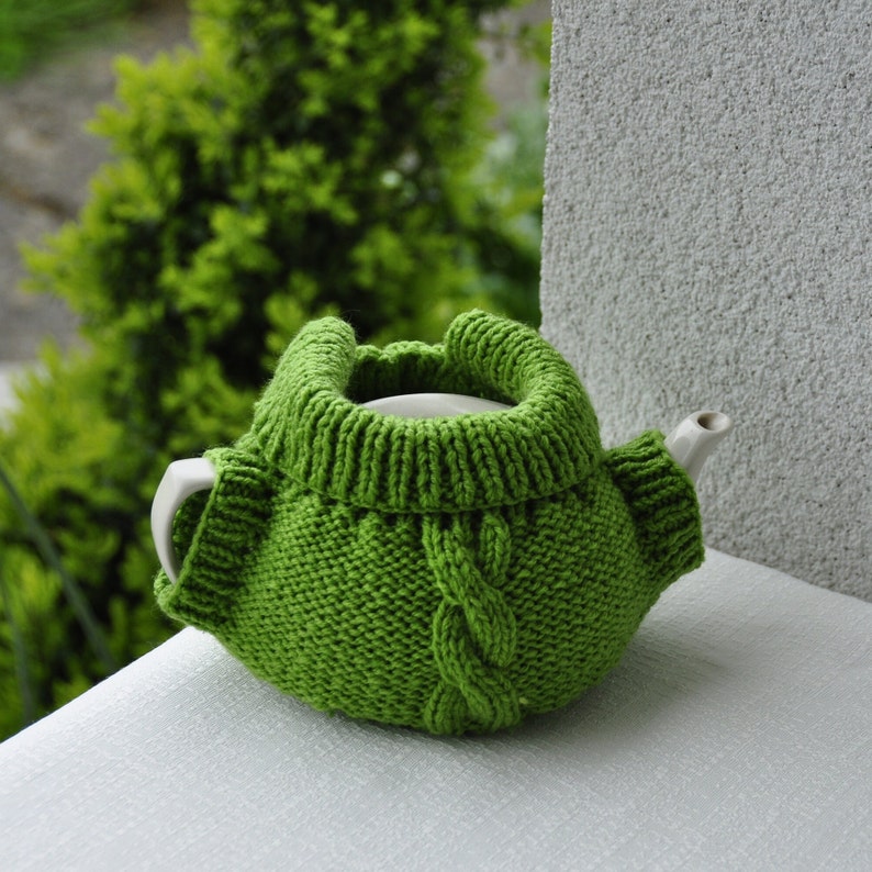 Jacket tea cozy with a pocket pattern, suitable for 4-6 cup pots about 1 liter volume. Six pages of detailed step-by-step instructions accompanied by pictures. Two small buttons added.