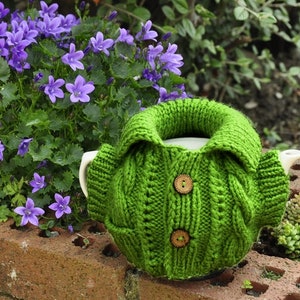 Jacket tea cozy with a pocket pattern, suitable for 4-6 cup pots about 1 liter volume. Six pages of detailed step-by-step instructions accompanied by pictures. Two small buttons added.