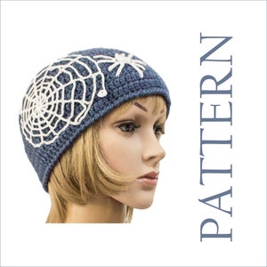 May include: A blue crocheted hat with a white spiderweb and spider design. The hat is displayed on a mannequin head. The word "PATTERN" is printed vertically in blue on the right side of the image.