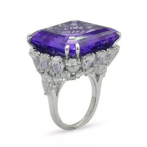 May include: A silver ring with a large, square-shaped purple amethyst gemstone surrounded by smaller, pear-shaped diamonds.